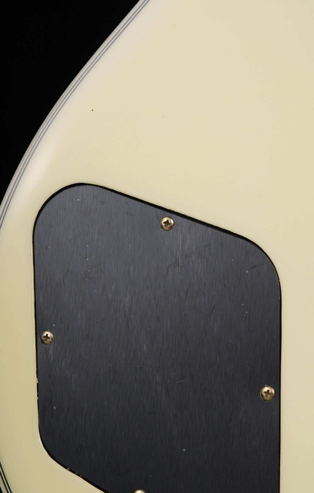 Edwards by ESP E-LP-130CD WH Les Paul Custom Antique White 2009 Seymour Duncan Pickups Close-up of a guitar with a black pickguard and gold screws on a beige background