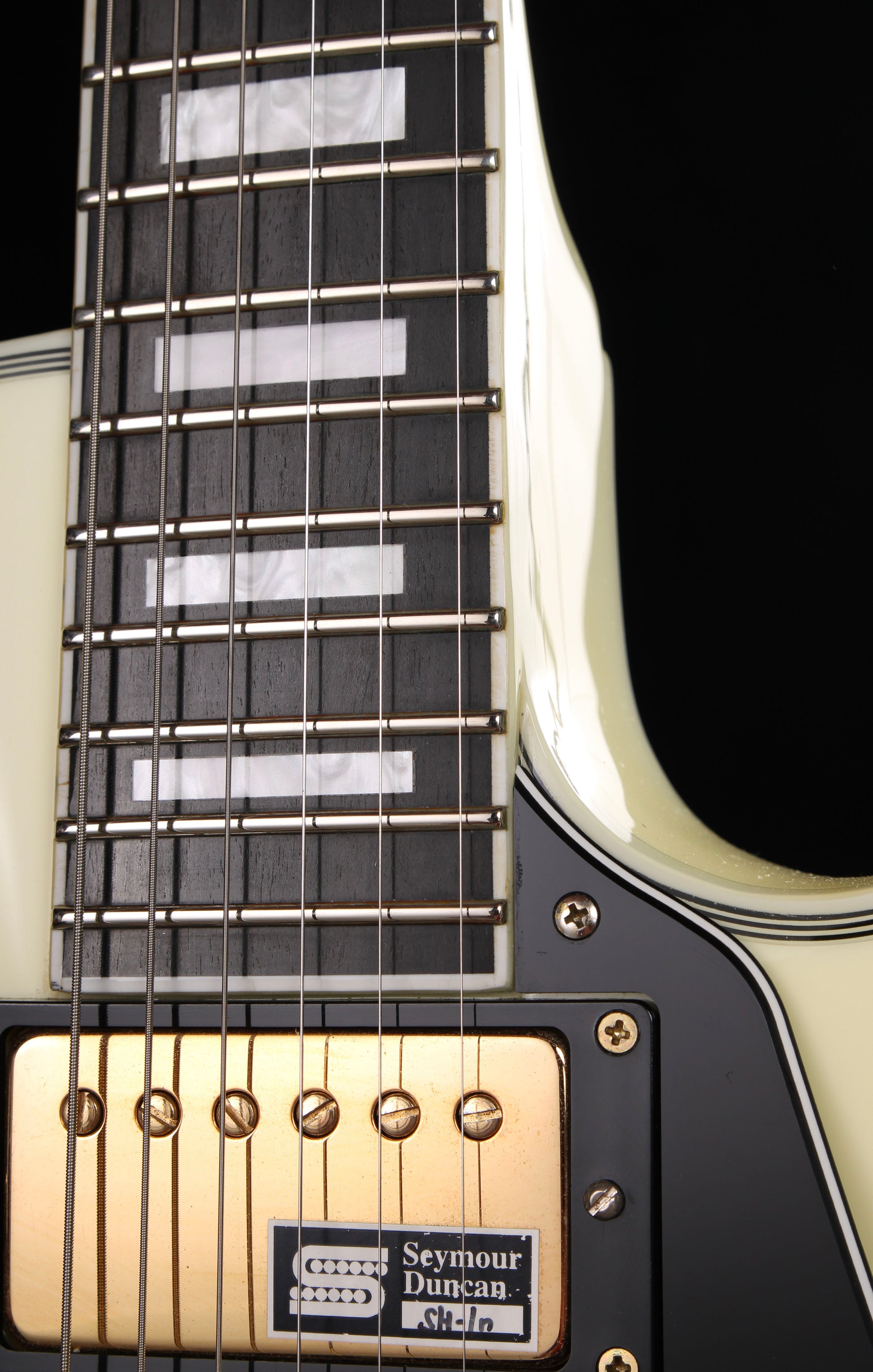 Edwards by ESP E-LP-130CD WH Les Paul Custom Antique White 2009 Seymour Duncan Pickups Close-up of a guitar neck with a Seymour Duncan pickup, on a black background