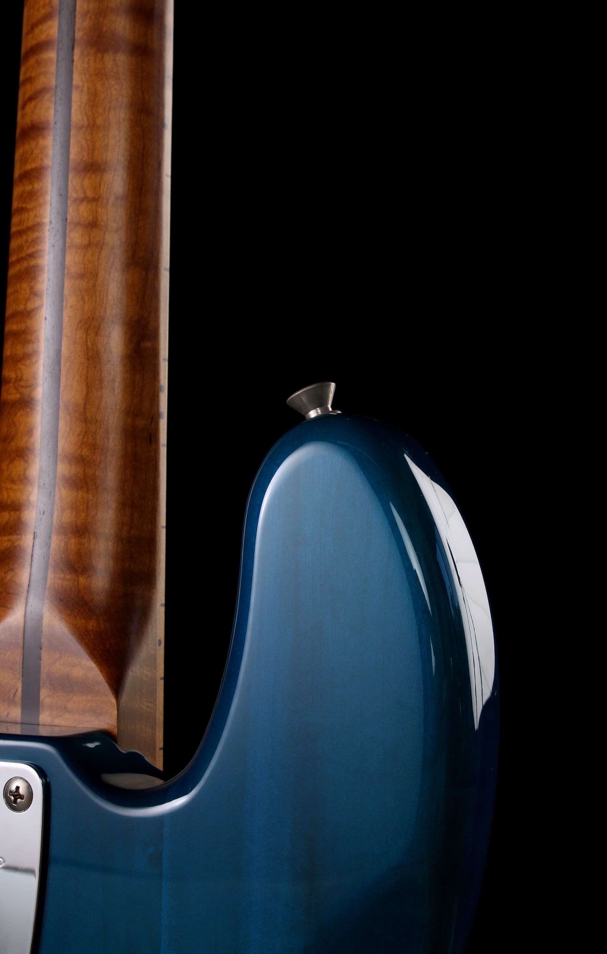 Close-up of a blue electric bass with a dark background