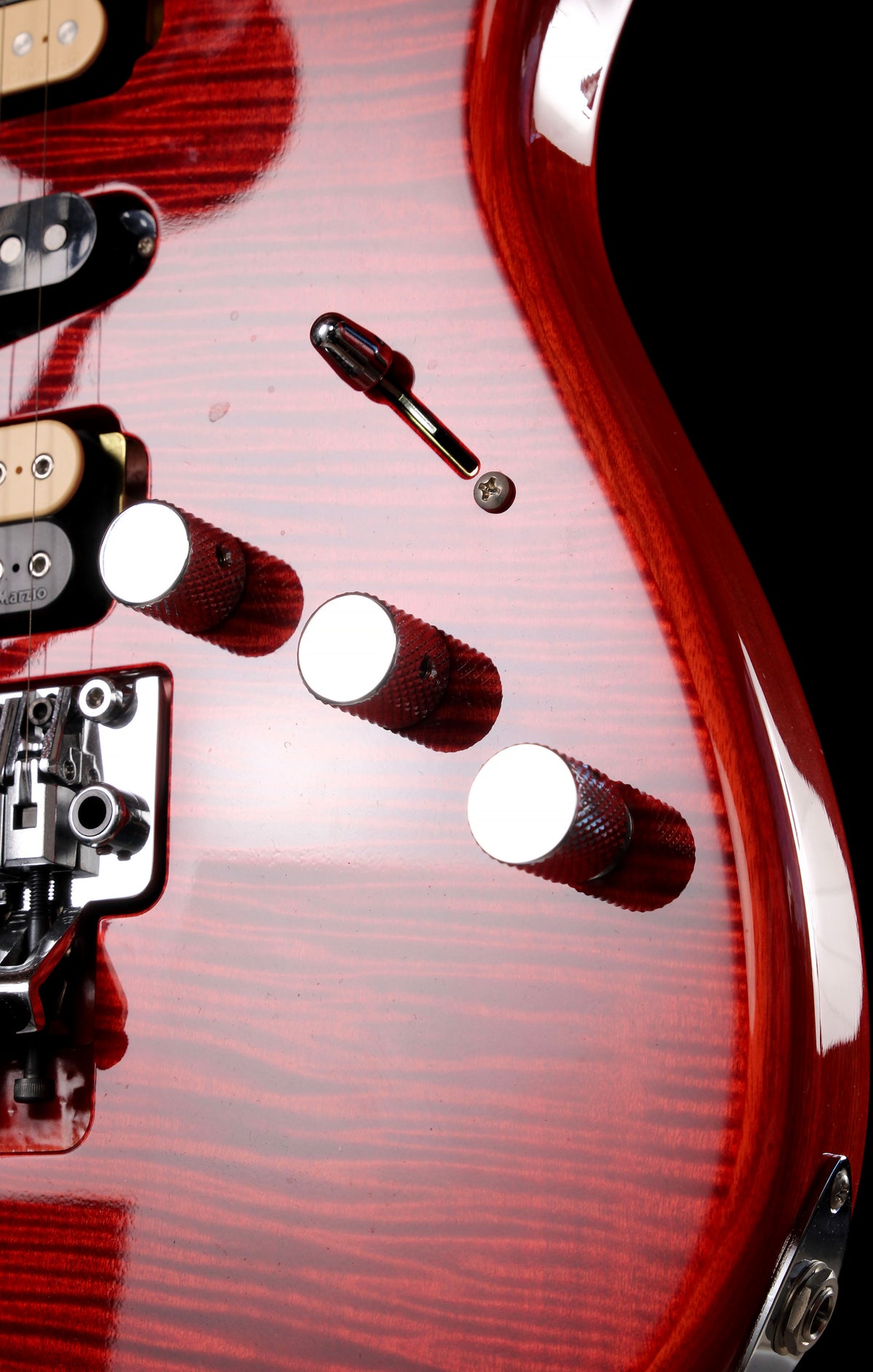 Fender Japan Michiya Haruhata Stratocaster Transparent Pink 2021: Close-up of a red electric guitar body showing the glossy wood grain finish, white control knobs, black pickups, and hardware against a dark background.