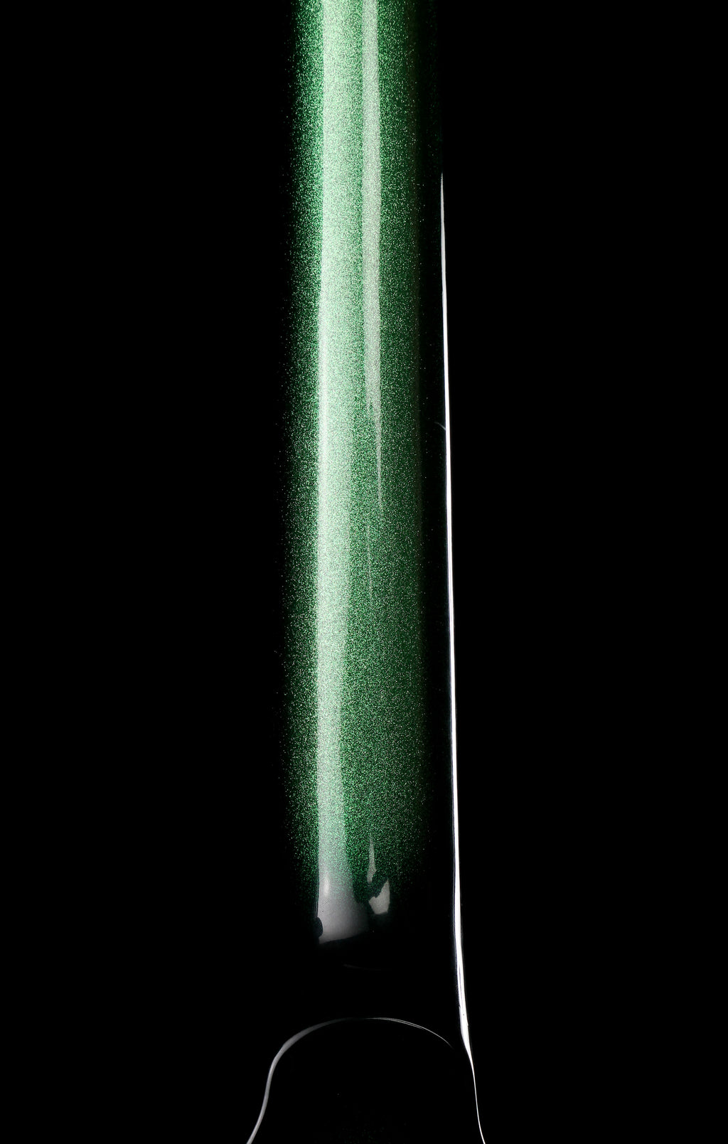 Fernandes EX Explorer Special Order SGS Sparkle Green Sunburst MIJ 1984: A close-up of a glossy green cylindrical product, likely a bottle or tube, shown against a solid black background with a bright vertical highlight.